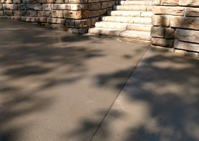 Concrete driveway with stone retaining wall and stone stairs