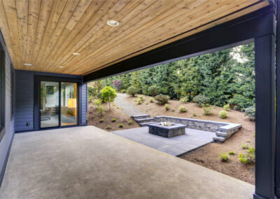Modern home with a backyard fire pit, concrete pathway and stairs, seating and a concrete patio