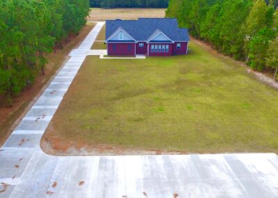 A concrete driveway and parking pad project in South Carolina shown from the back of the house