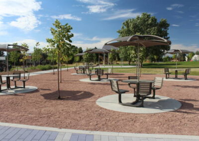 A park with concrete pads for picnic tables and mixed concrete and paver walkways