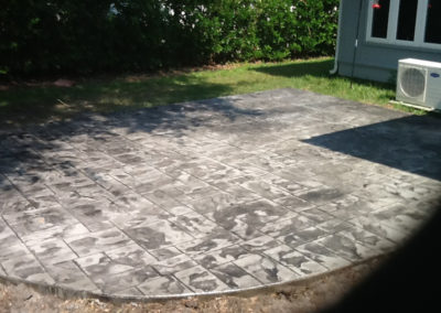 rounded patio of grey colored stamped concrete